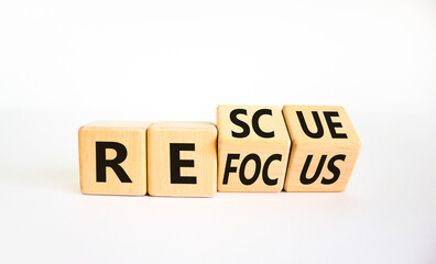 Refocus and rescue symbol. Businessman turned cubes and changed the word 'refocus' to 'rescue'. Beautiful white table, white background. Business refocus and rescue concept. Copy space.