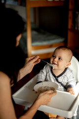 mom feeds baby porridge, baby has breakfast