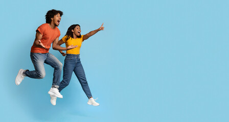 Carefree young black man and woman jumping in the air