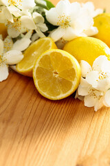 Flowering jasmine and lemons on a wooden background.