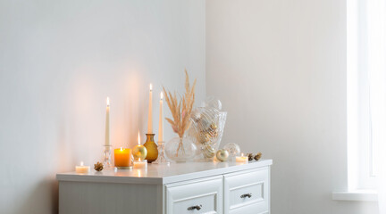 christmas decorations with burning candles in white room