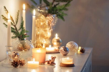 christmas decorations with burning candles in white room