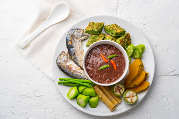 Spicy Shrimp Paste Dip (Nam Prik Kapi) served with Fried Egg with Climbing Wattle, fried mackerel fish and boiled vegetable.Top view