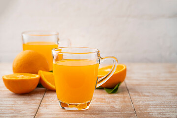 glass of fresh orange juice with fresh fruits on wooden plate