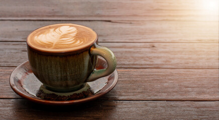 coffee in green cup on wooden table in cafe.