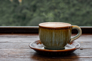 Fototapeta na wymiar coffee in green cup on wooden table in cafe.