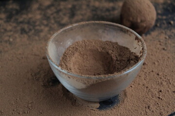 chocolate cake falls flying roll in cocoa powder. Preparation of dessert