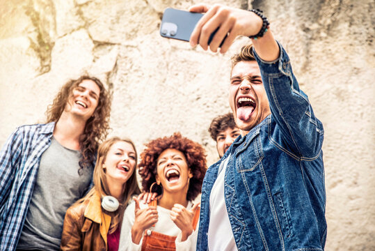 Happy multicultural friends group taking selfie with smart phone mobile outdoors - Millennial people taking picture sharing on social media platform - People, technology lifestyle and friendship