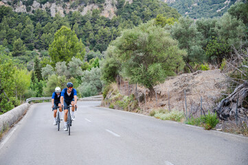 Two cyclists training on a mountain road