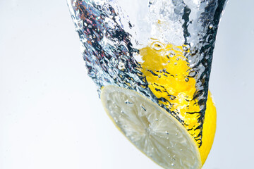 Yellow Lemon splashing Into Water, studio shot