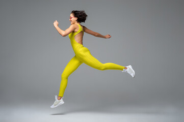 Fototapeta na wymiar Young sportswoman leaping and smiling