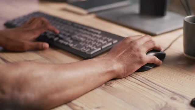 Crop man using keyboard and mouse