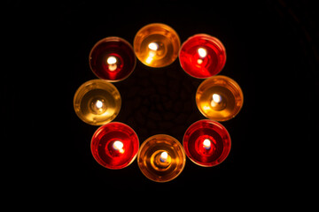 Candles are collected in a circle. A circle of wax candles. Liquid wax orange and red. Romantic...