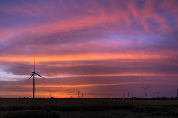 Wind turbines at dawn. Picturesque view of the wind power generator. Production of environmentally friendly energy.