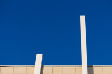Abstract architectural detail of a modern office building facade isolated with blue sky background