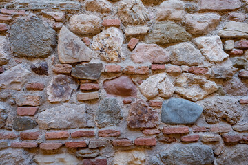 Stone and brick wall of an ancient building. Suitable as background and wallpaper pattern.