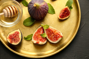 Fresh ripe figs with mint on a golden plate. Healthy mediterranean fig fruit. Top view