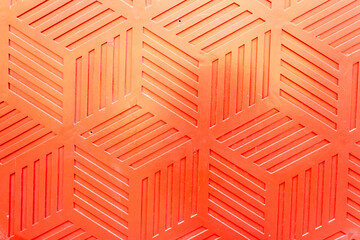 Red plastic surface with repetitive geometric shapes. Seamless geometrical patterns with rhombuses,...