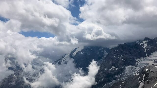 Timelaps: clouds moving over mountains. Dolomites and  Ortler in Italy, with snow. Stelvio Pass, Passo dello Stelvio. Timelapse