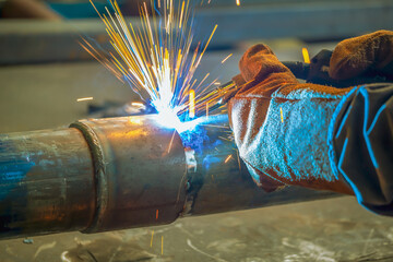 Pipe welding. The connection of the pipe with a clamp. Welder performs welding work semi-automatic...