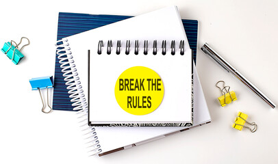 Sticker with BREAK THE RULES text on notebooks on the white background