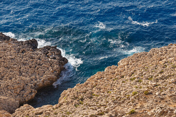 Sea waves on the wild rocky coast. Beautiful seascape. Travel concept. Seascape on the background of the wild rocky coast. Wild beach, azure water and rocks. Mediterranean sea, Cyprus. Postcard view