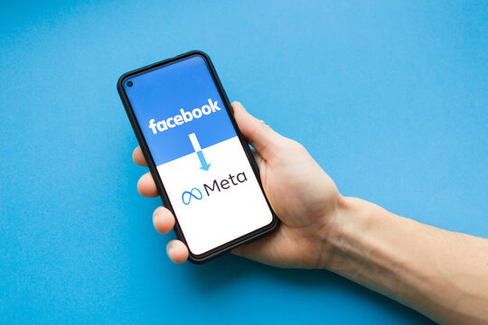 Nizhny Novgorod, Russia October 30 2021: facebook changed its name to meta. screen of smartphone phone with concept of renaming in hand on blue background