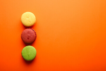 Beautiful composition with macaroons on a orange background with place for text. Top view