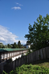 View of the monastery wall with a bell tower. Old fence made of boards. Rural panorama.