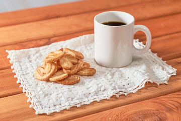 Palm cookies or puff pastry ears on a rustic background.