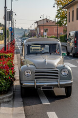 An antique Italian Fiat 500 Topolino Giardinetta car, parked along a city street - obrazy, fototapety, plakaty