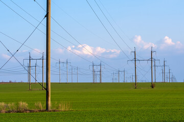 Fototapeta na wymiar High-voltage power lines. Transmission of electricity by means of poles through agricultural land.