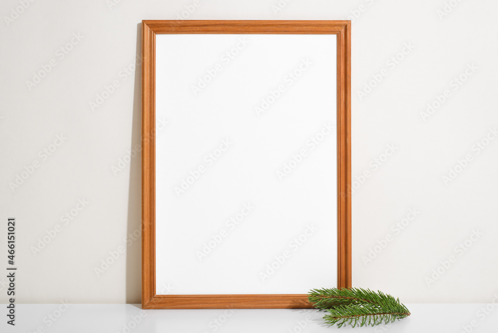 Poster frame mockup and twig of pine on table indoors. portrait vertical frame template with blank space, s