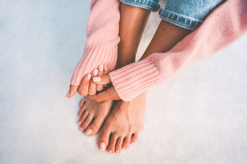 Stylish woman hands and feet with beautiful french manicure and pedicure on a white background with...