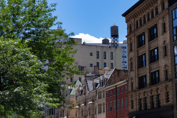 Obraz premium Row of Colorful Old Brick Apartment Buildings and Green Trees in the East Village of New York City during Summer