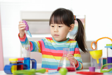 young girl playing color sorting and fine motor skill toy at home