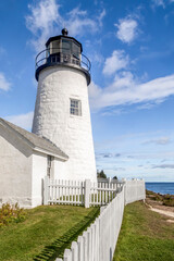 Fototapeta na wymiar Surrounded by a white picket fence, the historic Pemaquid Point Lighthouse stands on the granite shore of the Atlantic Ocean at Bristol, Lincoln County, Maine.