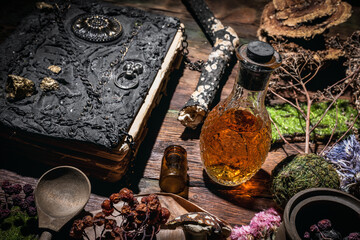 Concept of magic book, dry herb and magic potion on the wooden table background. - obrazy, fototapety, plakaty