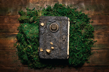 Ancient magic book on the wooden flat lay table background.