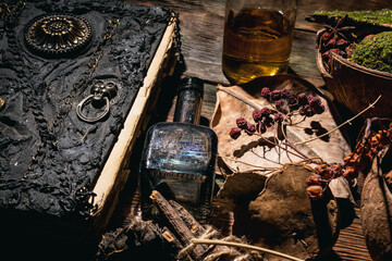 Concept of magic book, dry herb and magic potion on the wooden table background.