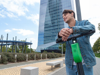 Latin man in a sweater and blue pants riding a scooter in a place with many tall buildings
