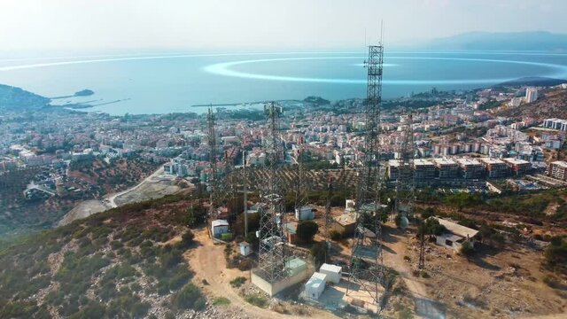 Animated visualization of mobile network signals originating from a cell towers. Telecommunication antennas are located on the top of a hill near the city. 5g cellular mobile wave signal transmission.