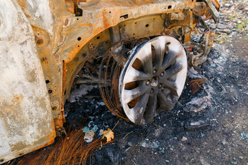 Burnt car wheel stands on the ground