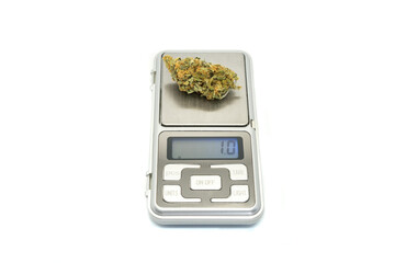 Digital weight weighing marijuana buds isolated on white background. A gram of cannabis on digital...