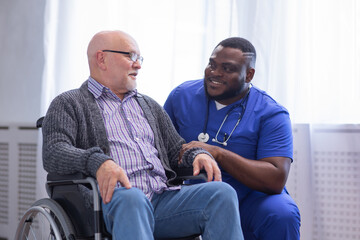 Caregiver and old man in a wheelchair. Professional nurse and patient in a nursing home....