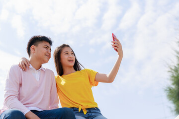 Self portrait of two asian teenager friends cloud sky background