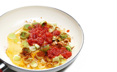 Slice leek and tomato cubes in sunflower oil isolated on white