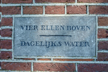 Fototapeta vier ellen boven dagelijks water een tekst op een gedenksteen, Schokland, Flevoland province, The Netherlands obraz