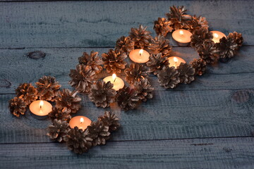 Christmas background of festive silver pine cones in fire burning candles