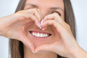 Teeth care. Woman with beautiful smile with strong white teeth. Dental care. Woman holding heart...